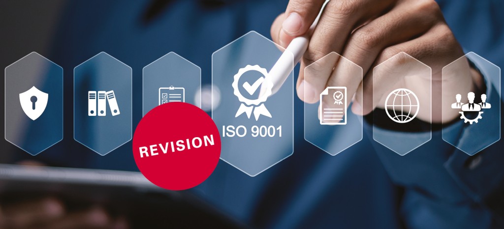 Person using digital pen to highlight ISO 9001 certification icon on virtual screen, with red “Revision” label.