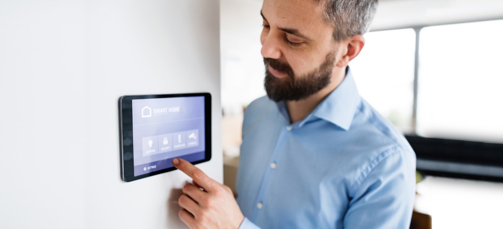 Male at a touch screen using Matter certified smart home technology | TÜV Rheinland