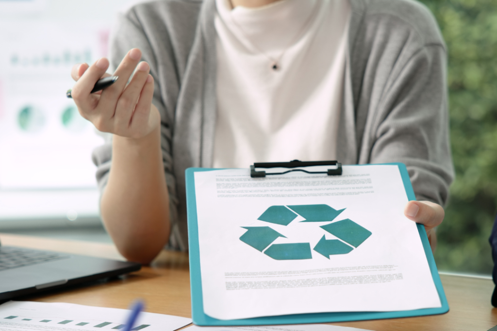 Woman showing a clipboard with a recycling symbol.