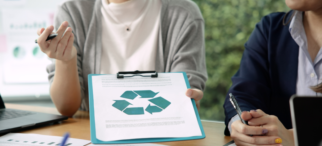 Woman showing a clipboard with a recycling symbol.