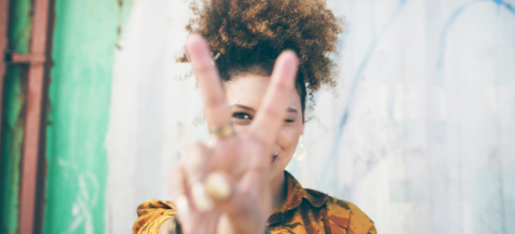 Eine junge Frau zeigt das V-Zeichen