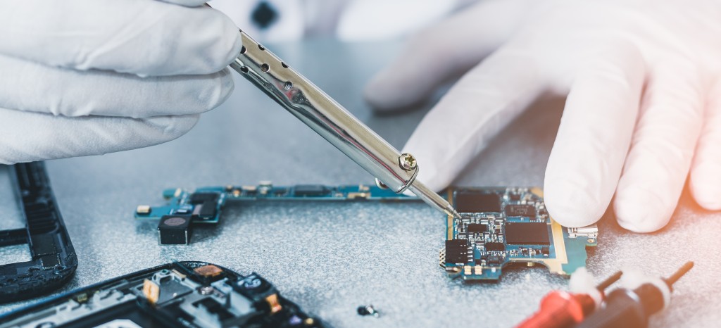 Technician soldering a smartphone circuit board
