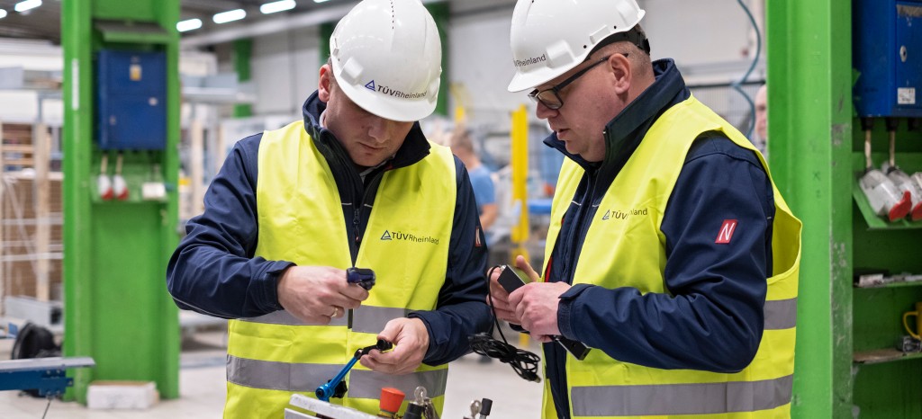 Dwóch inspektorów sprawdzających bezpieczeństwo maszyn